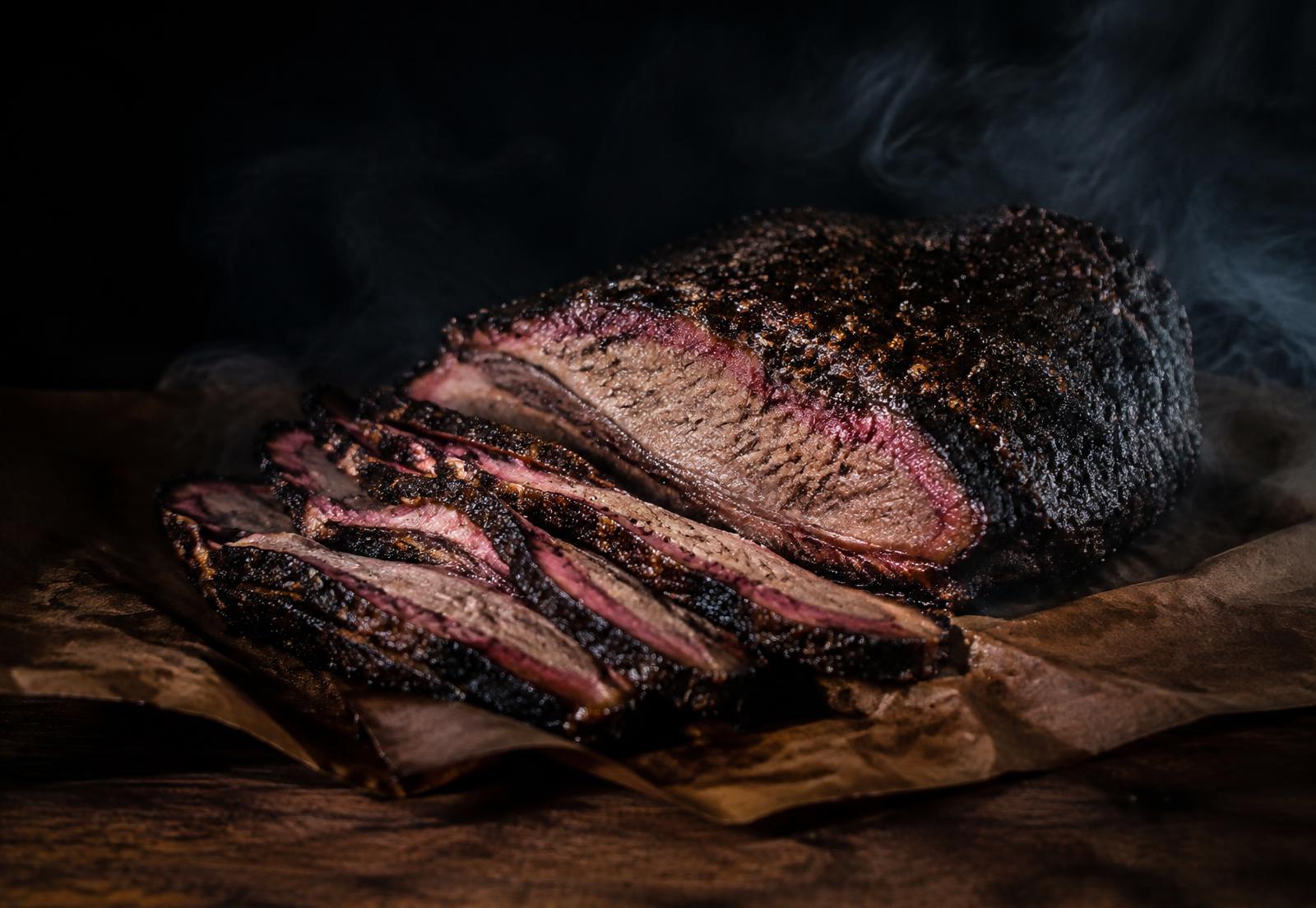 Sliced smoked brisket with a peppery bark